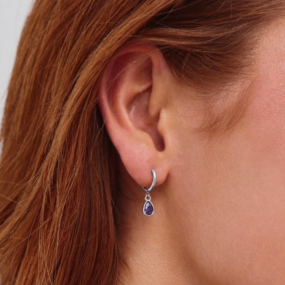 Silver Purple Teardrop Earrings, worn in a pierced ear, silver hoop with purple teardrop drop